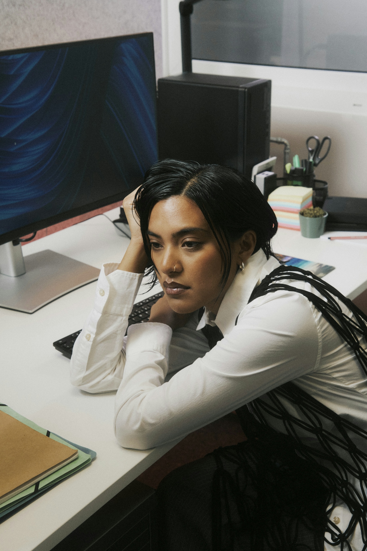Woman tired resting on corporate work desk, showing exhaustion about her job.